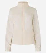 Campera deportiva femenina, modelo rompevientos, confeccionada en poliamida, con cuello alto y puños ajustados. Sin estampa, tiene cierre delantero con cremallera y recortes con hilo reflectante.