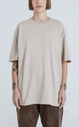 Remera color arena de corte crop y calce oversize, con hombros caídos y cuello redondo.