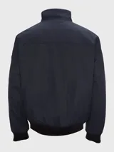 Campera bomber azul marino de poliéster con cuello alto, cierre frontal con cremallera, puños y dobladillo elásticos, dos bolsillos laterales con cremallera y un bolsillo pequeño con cremallera en la manga izquierda.