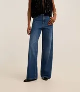 Pantalón de jean de corte wide leg, tiro alto y cintura sastre.