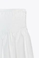 Falda midi blanca de popelín con cintura elástica tipo nido de abeja.