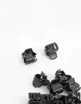 Set de 20 minibroches negros para el cabello, presentados en una bolsita plástica transparente con cierre y cadena metálica.