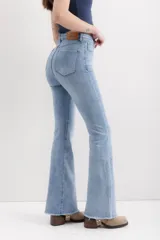Pantalón de jean celeste de corte acampanado, tiro alto y ruedo desflecado.