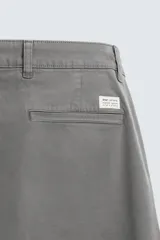 Pantalón chino color beige, corte skinny fit, confeccionado en tejido con mezcla de algodón y elasticidad. Cuenta con bolsillos frontales y traseros. Cierre frontal con cremallera y botón.