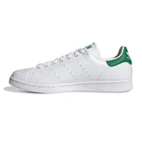Championes Adidas Stan Smith blancos de cuero, con detalles verdes en el talón y la lengüeta. Diseño clásico con perforaciones laterales y suela de goma.
