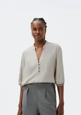 Blusa color marrón con cuello mao, escote en V y mangas 3/4 abullonadas.