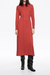 Vestido de largo midi en color negro con corte en línea A y vuelo. Posee escote barco, mangas largas tipo murciélago ajustadas en los puños y detalles de pespuntes decorativos a contraste. Está confeccionado en una mezcla de cupro y elastano.