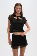 Top negro de poliéster con mangas cortas, cuello redondo, corte ajustado y abertura en el pecho.