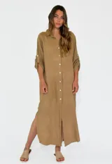 Vestido camisero largo color beige, con cuello clásico, abotonadura frontal completa, mangas 3/4 con trabilla y aberturas laterales.