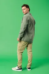 Pantalón cargo color verde oliva, corte slim fit, con bolsillos laterales con solapa y cierre de botón a presión.