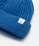 Gorro corto tipo beanie color beige, tejido en lana acrílica con textura acanalada.