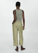 Pantalón negro de lino con diseño crop y jogger, tiro medio, cintura elástica con lazo, dos bolsillos laterales y dos bolsillos de ribete en la parte posterior.