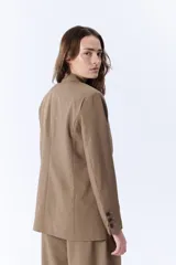Blazer negro con corte entallado, confeccionado en poliéster y viscosa, ideal para un look elegante.