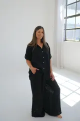 Pantalón palazzo negro de lino con cintura alta y lazo ajustable.