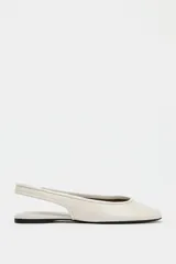 Zapato tipo bailarina destalonada en color crema, con detalle de pespunte en el corte, tira trasera con pieza elástica y acabado en punta redonda.