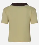 Blusa color amarillo claro confeccionada en tejido rib, con cuello polo marrón, manga corta y cierre frontal con botones marrones.