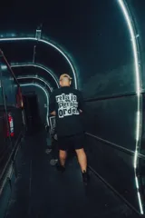 Remerón negro de manga corta y corte holgado, con estampado en la espalda con tipografía estilo recorte de periódico que dice "relajo pero con orden".