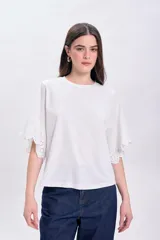 Remera blanca de algodón con mangas cortas y detalle de broderie calada en los bordes.