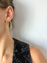 Aros colgantes ovalados de bronce con textura irregular.