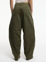 Pantalón slouchy marrón de tiro alto con cierre de botón y cremallera, pretina con pasacinto y rayas blancas laterales.