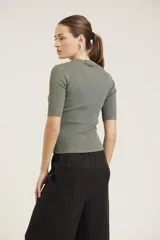 Blusa de punto color beige, de mangas cortas y cuello alto.