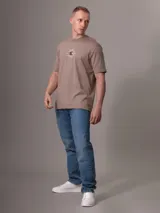 Remera color beige con cuello redondo y mangas cortas. Estampado frontal con diseño de sello de la ciudad de Nueva York y monograma bordado.