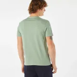 Camiseta verde de manga corta con cuello redondo y estampado blanco con la frase "Nice Trip" y un dibujo de edificios y palmeras.