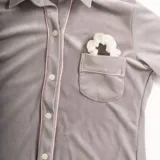 Pijama celeste de terciopelo, compuesto por una camisa de manga larga con botones y vivo blanco, bolsillo en el pecho y un pantalón recto con elástico en la cintura.