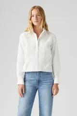Camisa blanca de manga larga con bordado floral en el frente y detalle de puntilla en los puños.