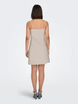 Vestido mini color beige con breteles finos y escote cuadrado.