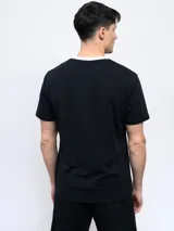 Remera color arena de corte clásico con cuello redondo ribeteado en blanco y logo Umbro estampado en el pecho.