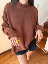 Buzo color marrón con cuello alto y mangas largas terminadas en volados.