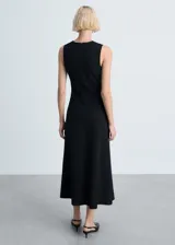 Vestido midi negro sin mangas, con cuello redondo y corte ajustado al cuerpo.