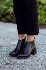 Botines negros de cuero con cierre lateral y taco geométrico.