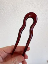 Pinza para el pelo tipo peineta, color vino, con forma irregular. Fabricada en acrílico.