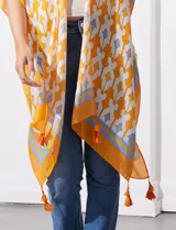 Kimono tejido color naranja con estampado geométrico en blanco y celeste, y terminación con borlas.