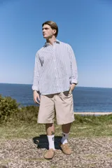 Short color beige de tiro medio con cierre de cremallera, bolsillos delanteros y traseros.