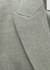 Blazer gris cruzado con cuello de pico con solapa, tejido de mezcla de lana, diseño recto y largo, manga larga con puños abotonados, forro interior y bolsillos de ribete en el pecho y de solapa laterales.