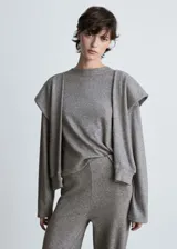Sweater gris de punto fino con cuello redondo, mangas largas y mangas decorativas.