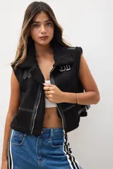 Chaleco negro de diseño sin mangas, con forro de peluche y detalles de cierre metálico.