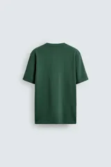 Camiseta verde oscuro de corte relaxed fit, cuello redondo, manga corta y bolsillo plastrón en el pecho.