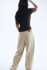 Remera negra de punto crepé con escote redondo y mangas cortas. Diseño ajustado con frunces en un hombro y en el lado opuesto de la cintura para crear un leve efecto drapeado.