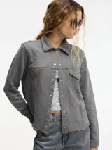 Sobrecamisa gris con broches metálicos en la parte delantera, bolsillo con solapa y cuello camisero.