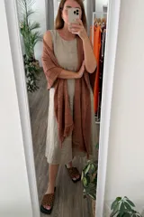 Ruana tejida color marrón terracota, con diseño calado de puntos y terminaciones con flecos.