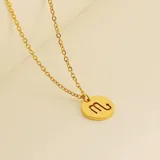 Collar dorado con dije redondo con el signo de Aries grabado.