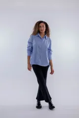 Camisa de corte clásico, color celeste, con cuello y botones, de manga larga.