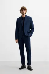 Blazer slim fit azul marino confeccionado en tejido con viscosa. Tiene cuello con solapas de muesca, manga larga con puño con botones, bolsillo de vivo en el pecho, bolsillos de solapa en la cadera, bolsillo interior y aberturas en la espalda.