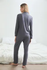Pijama de viscosa y poliamida color gris con ribetes blancos, compuesto por camisa de manga larga con botones y pantalón largo.