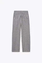 Pantalón de tiro medio con cintura elástica ajustable con cordones, bolsillos delanteros y traseros de parche. Pierna ancha con estampado de rayas verticales azules y blancas.