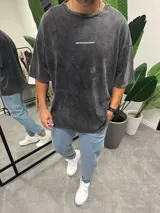 Remera gris oscuro con efecto lavado, corte holgado y mangas cortas. Estampado pequeño con la leyenda "BOHEMIANDESIGN" en el pecho.